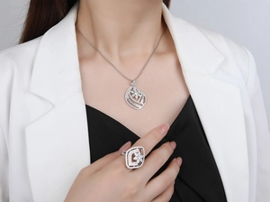 Close-up of sparkling hollow floral S925 silver jewelry set worn with white suit