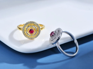 Close-up of gold and silver hollow pavé rings with a centered round red gemstone