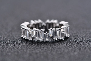 Macro shot of S925 silver ring featuring baguette cut stones in a classic eternity band