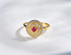 Top view of a gold-plated cluster ring featuring a red ruby center and CZ halo detail