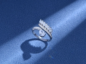 Close-up of S925 silver crown ring with pear-cut zircon on dark textured surface