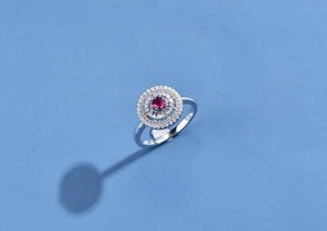 Macro shot of 925 silver ring with a red ruby center stone and micro-pave diamond halo