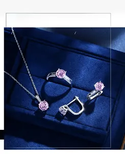 Three-piece jewelry set with pink stones in a blue velvet box including ring and necklace