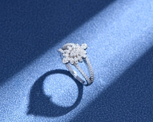 Macro detail of leaf-shaped silver ring with micro-pave diamonds on navy surface