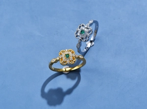 Dettaglio macro di anelli retrò in oro e argento con pietre verdi taglio smeraldo e diamanti pavé