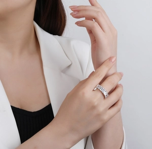 Détail d'une bague éternité avec zircons taille émeraude sur le doigt du modèle