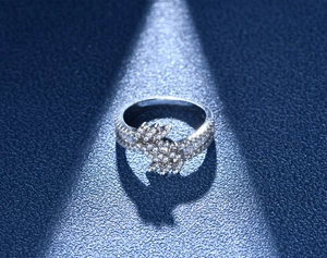Macro shot of 925 silver leaf ring with double row micro paved zircons on blue backdrop