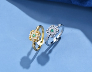 Dettaglio macro di anelli a quadrifoglio in argento 925 con gemma verde smeraldo