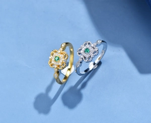 Dettaglio di anelli a quadrifoglio vintage in oro e argento con smeraldi verdi