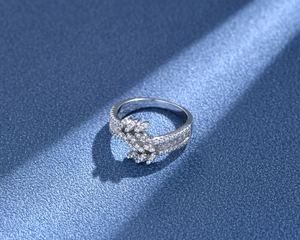 Detail of 925 silver leaf ring with double row pave diamonds on a textured dark base