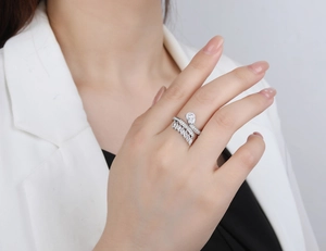 Detailed view of sterling silver feather ring with pear-cut cubic zirconia on a model