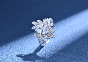 Detail of egg-shaped silver ring with oval gemstone and feather-like pavé diamonds