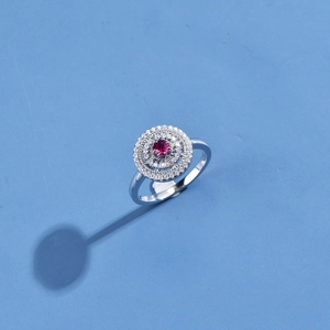 Polished silver ring with a vibrant red round center stone and double halo of white zircon