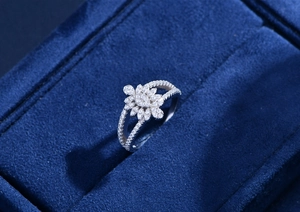 Detailed macro view of S925 silver leaf ring with micro-pave diamonds on blue velvet