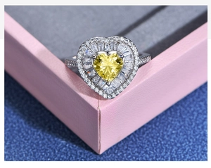 Macro shot of a heart-shaped yellow diamond ring with tiered side stones on a pink box