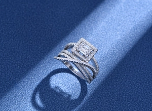 Macro shot of silver ring with square cluster setting and multi-layer diamond bands