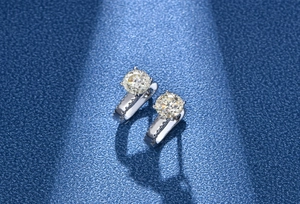 Detail of 925 silver stud earrings featuring 6.5mm four-prong round cut light yellow stone