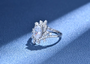 Macro view of 7x9mm oval faux diamond ring with radiant leaf-shaped pave accents