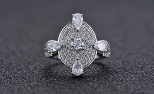 Macro shot of silver ring with pavé diamonds and pear-cut center stones detail