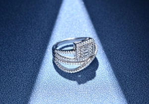Macro shot of silver multi-layer micro-pave ring with rectangular center on blue background