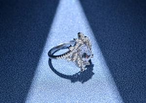 Macro shot of 925 silver ring featuring oval-cut center stone and floral halo setting