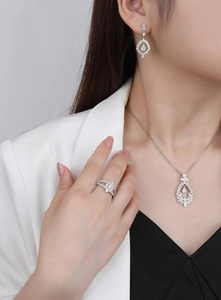 Detailed view of silver jewelry set with necklace and earrings on a model outfit