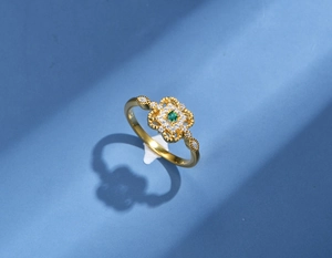 Dettaglio macro di anello in argento 925 con filigrana vintage e gemma quadrata verde