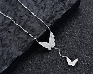 Detail of S925 silver butterfly tassel necklace with pavé zircons on black rock