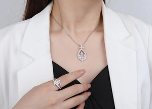 Close-up of S925 silver necklace and ring set with micro-pave leaf halo and zircon stones