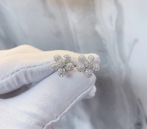 Détail de boucles d'oreilles fleur pavées en argent 925 avec cristaux scintillants