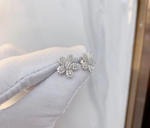 Vue macro des boucles d'oreilles fleurs en argent serties de zircons fins
