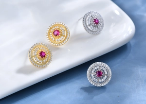 Macro shot of circular镂空earrings with red synthetic rubies and pavé zircons