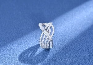 Macro shot of silver multilayer wavy ring with pave diamonds on dark texture