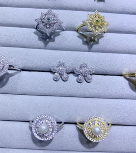 Boucles d'oreilles fleurs et bagues flocon en pavé dans un plateau en velours