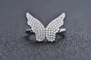 Vue macro d'une bague papillon ornée de zircons sertis pavé sur métal argenté poli