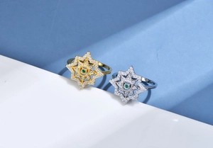Detail of gold and silver octagram rings with pavé diamonds and green gemstones