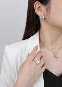 Close-up of radiant silver swirl jewelry set with crystals worn by a model