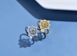 Macro shot of 925 silver star rings with gold and silver finishes and green gemstones