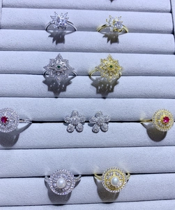 Vue détaillée de boucles d'oreilles fleurs et bagues en micro-pavage sur plateau