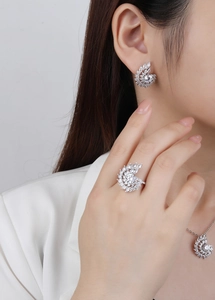 Close-up of model wearing silver spiral necklace and earrings set with sparkling zircons