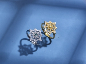 Detailed view of 925 silver and 18K gold star rings with green gemstones and white diamonds