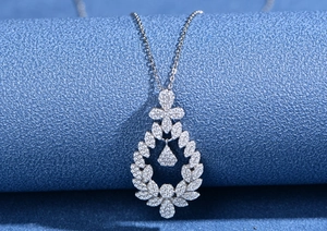 Macro shot of silver S925 necklace pendant with leaf wreath and sparkling pavé diamonds