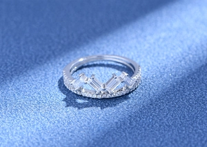 Macro detail of crown ring featuring baguette-cut zircon stones and silver pave band