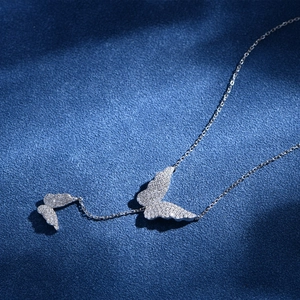 Sparkling S925 silver double butterfly pendant necklace with pavé crystals on a blue background