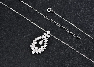 Macro view of S925 silver necklace with micro-pave leaf pendant and sparkling stone