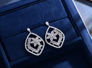 Close-up of S925 sterling silver flower earrings with zircons on blue velvet