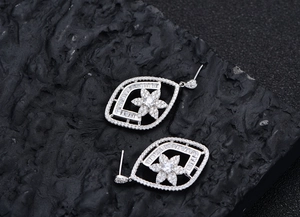 Macro shot of S925 silver flower earrings with micro-pave zircons on black rock