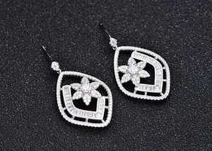 Detailed view of silver rhombic floral earrings with pavé set cubic zirconia stones