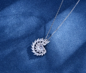 Detail view of silver spiral nautilus pendant featuring marquise and round cut crystals