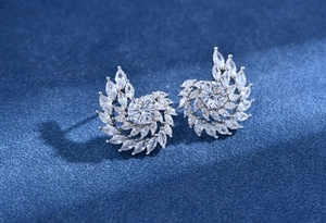 Gros plan de boucles d'oreilles spirales avec cristaux marquise sur velours bleu